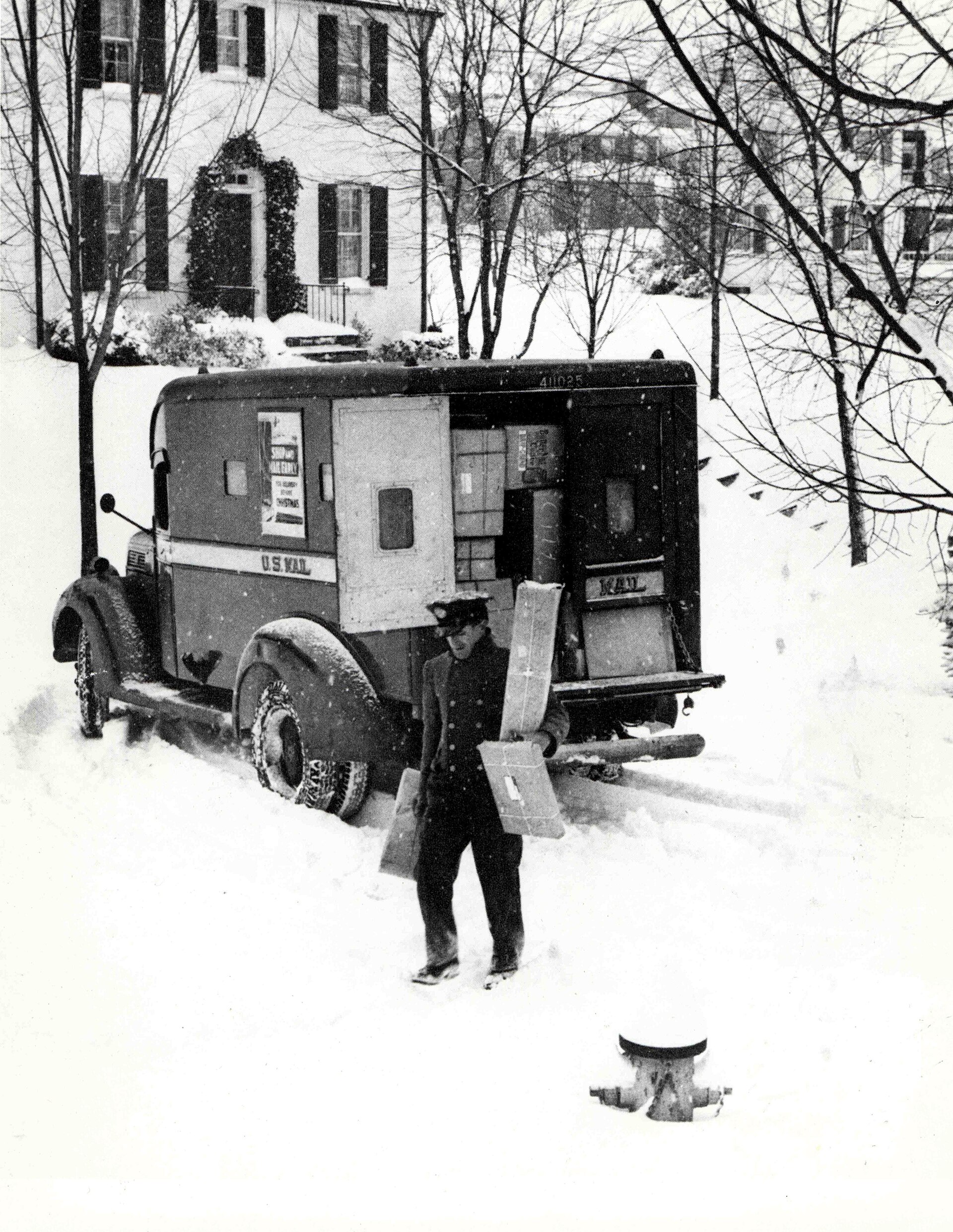 A parcel post carrier delivering packages in the snow
